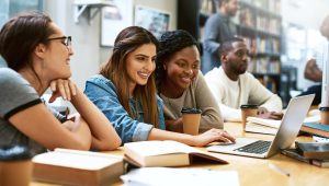 Shot of young women using a laptop together in a college library